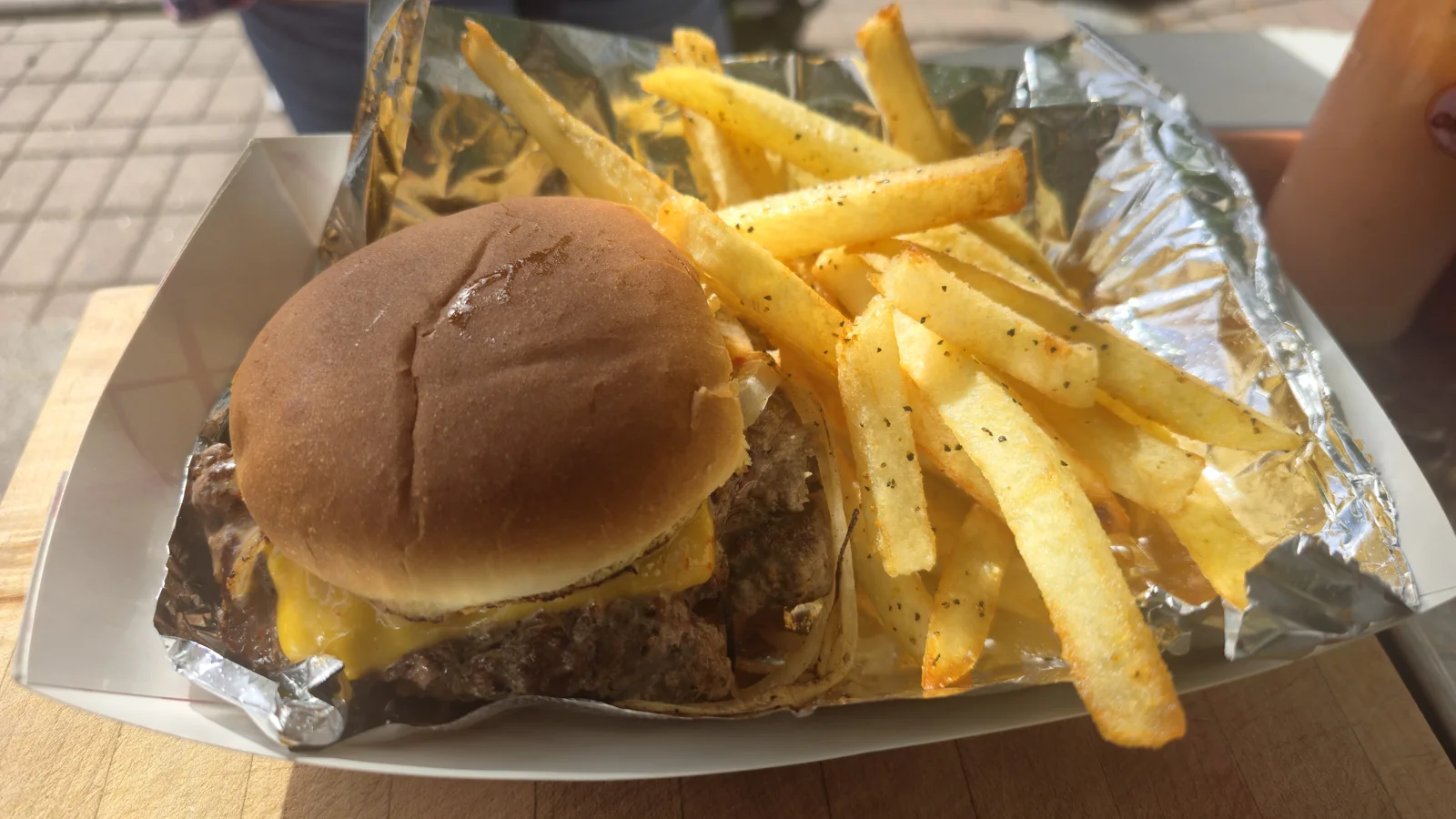 A smash burger with tallow fries in a paper boat